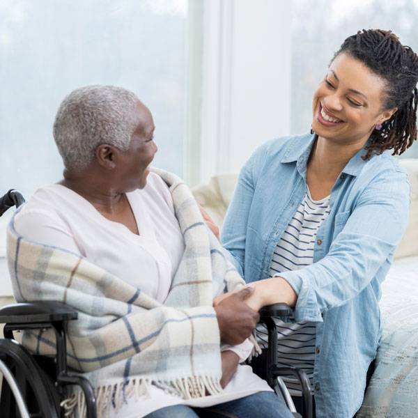 woman talking to older woman in wheelchair
